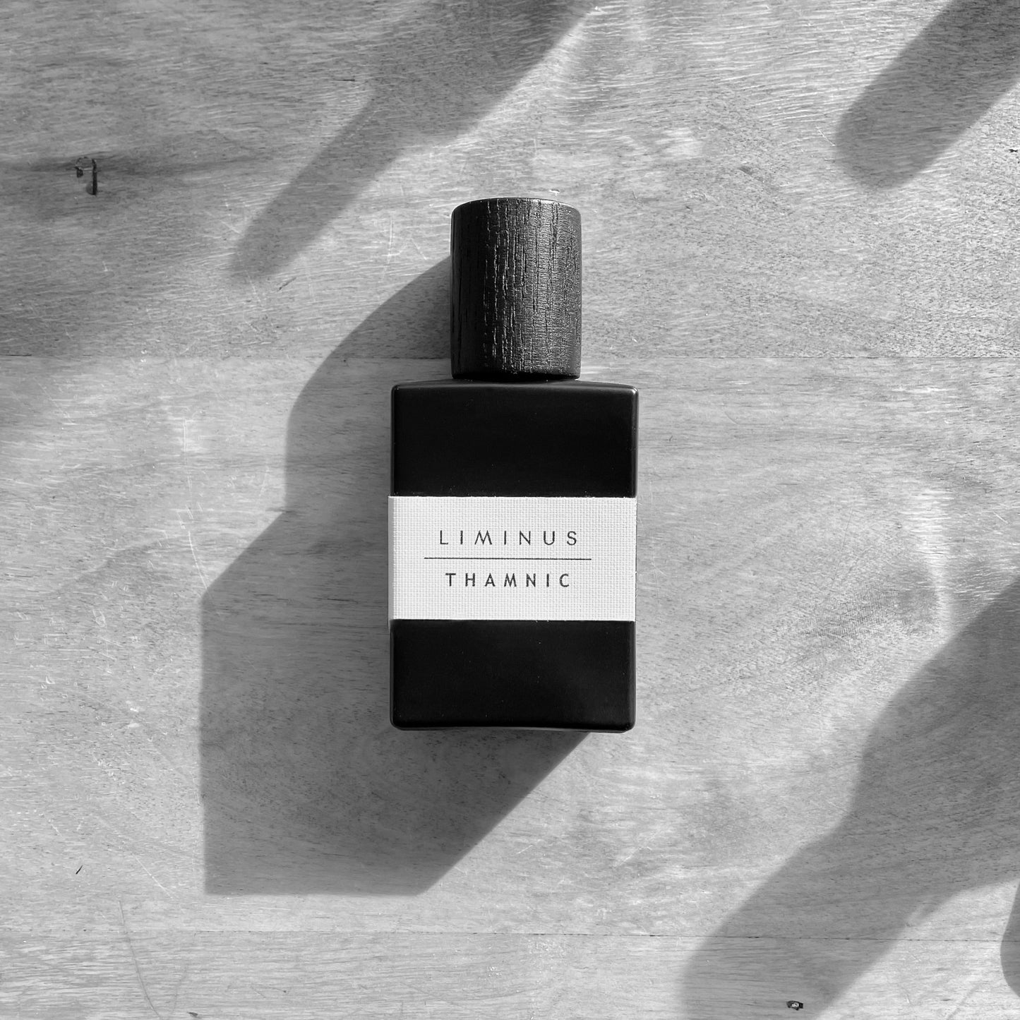 natural perfume 30 ml bottle on a wooden surface, black and whit