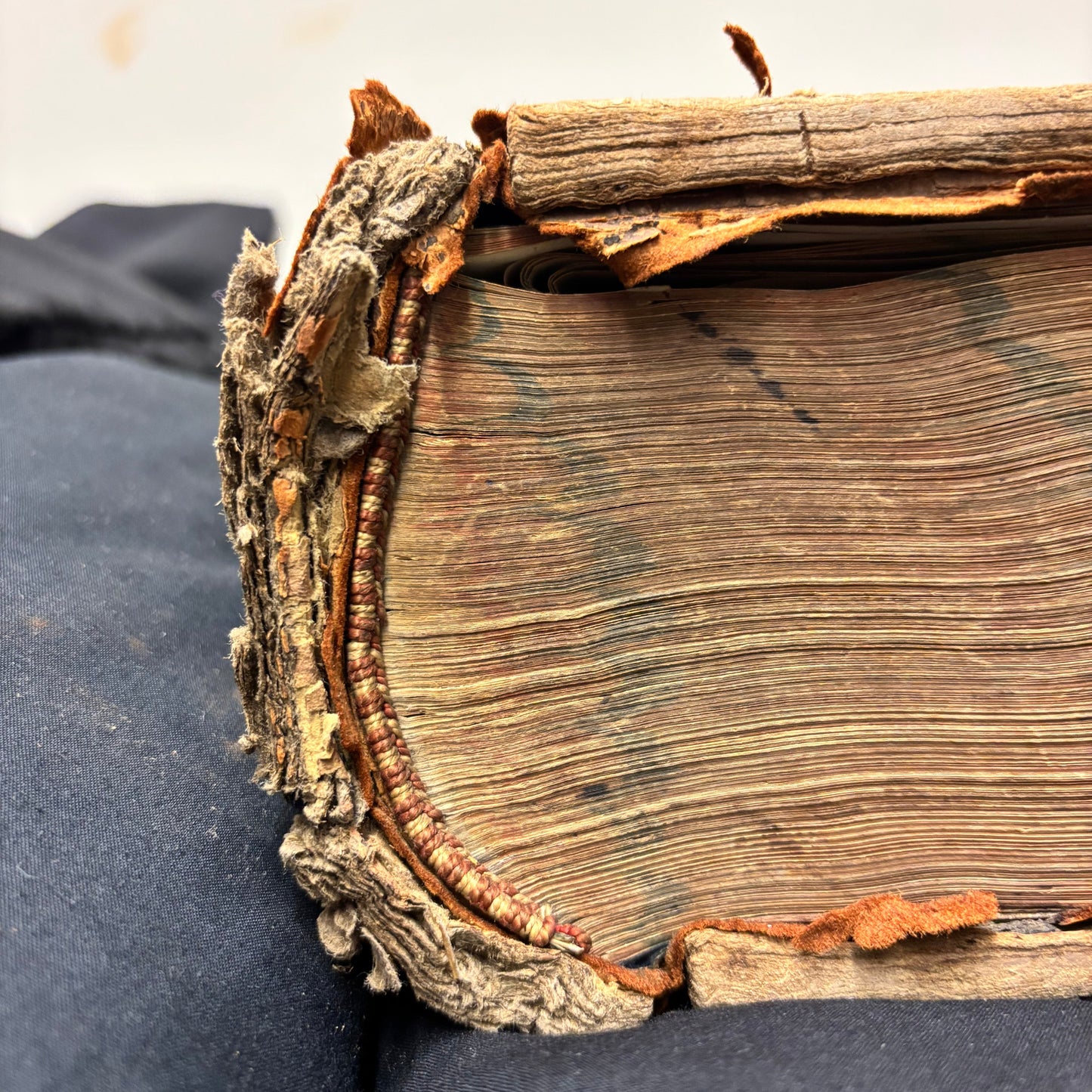 Close-up of an old, worn book with a dark background