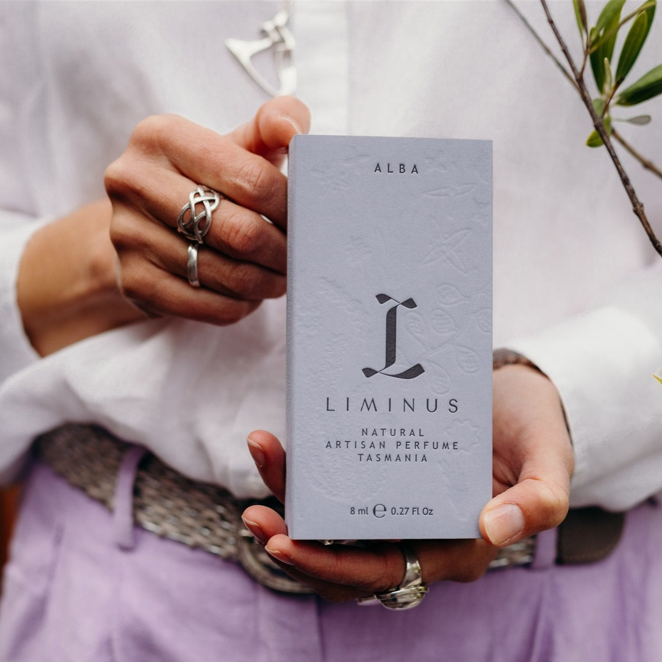 hands holding box of Alba perfume